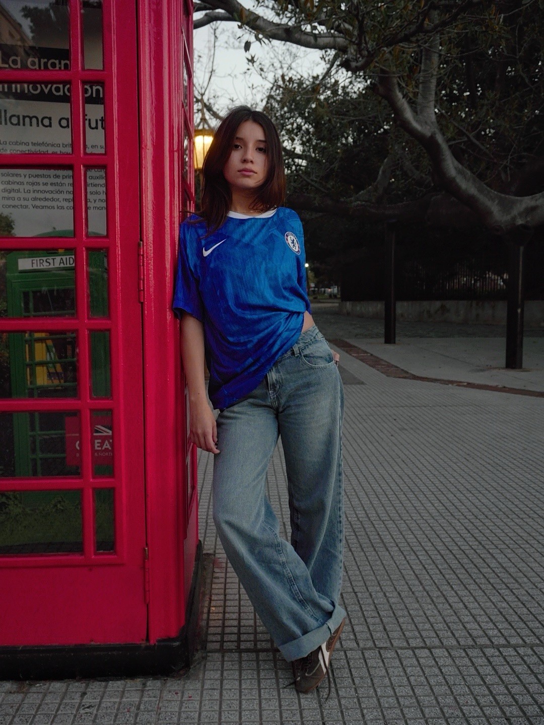 Retrato urbano con camiseta del Chelsea junto a una cabina telefónica roja