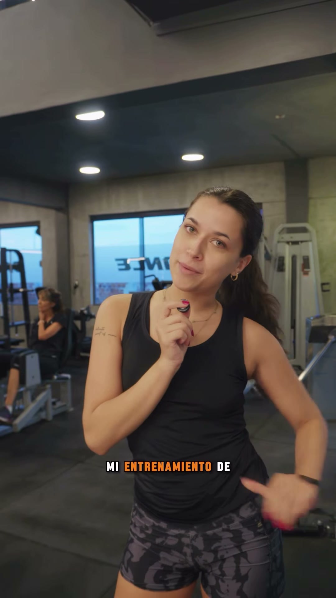 Aldi sosteniendo un micrófono en Balance Fitness, fotograma de su reel